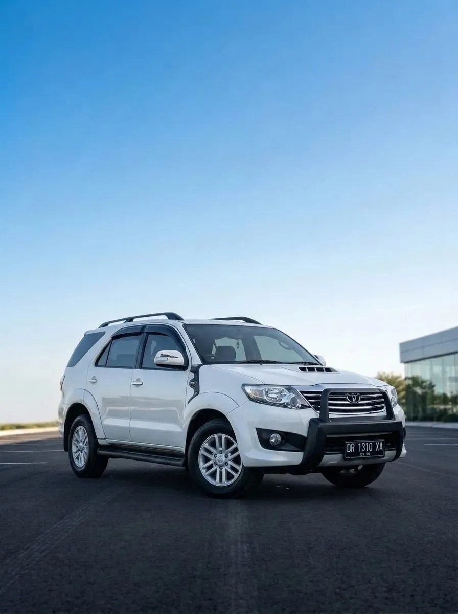 Toyota Fortuner putih dengan bumper depan, terparkir di bawah langit biru